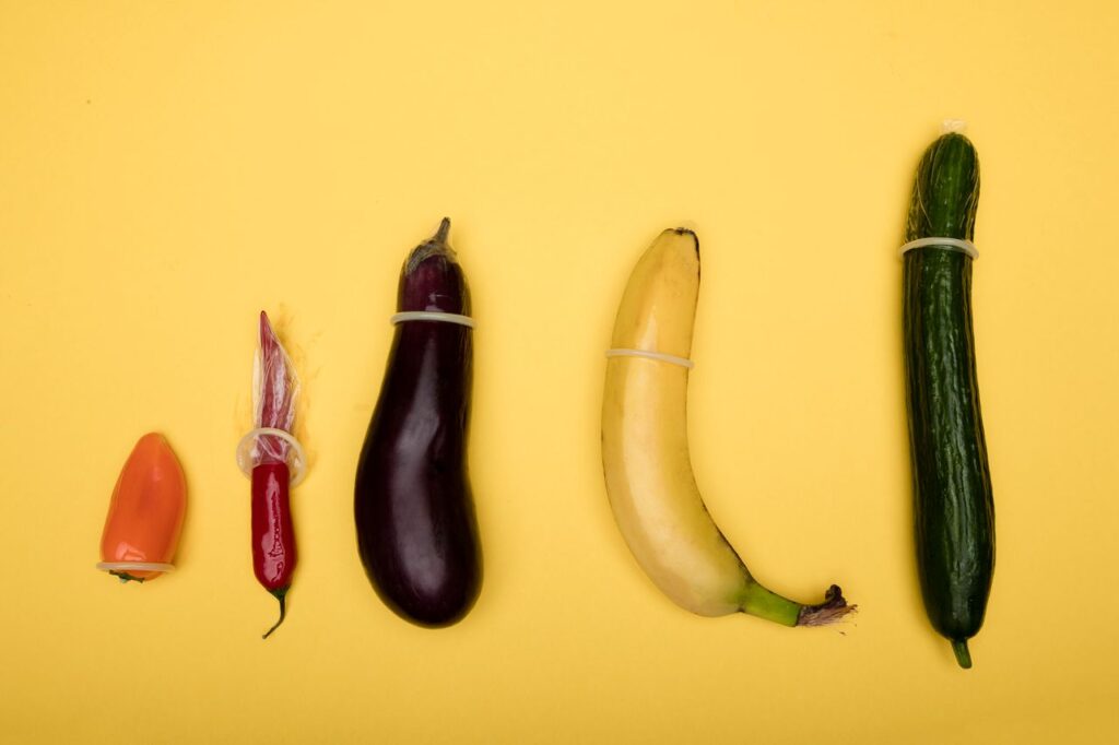 A humorous representation of contraceptives on vegetables against a yellow background.